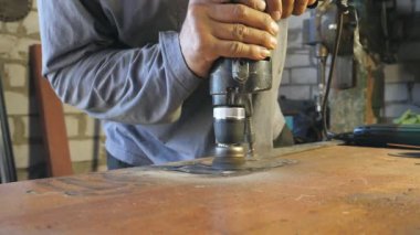 Operasyon sırasında mekanik tutuş aletinin elleri. İşçi ayrıntıları masaya koyar. Adam garajında ya da atölyesinde çalışıyor. Sıkı çalışma konsepti. Yavaş çekim. Dolly 'yi çek..