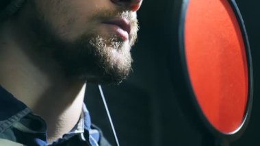 Erkek şarkıcı şarkı ses stüdyosunda mikrofona kulaklık kapatın. Duygusal olarak yeni şarkı kayıt genç adam. Yaratıcı müzisyen çalışma. Haritayı iş kavramı. Ağır çekim.