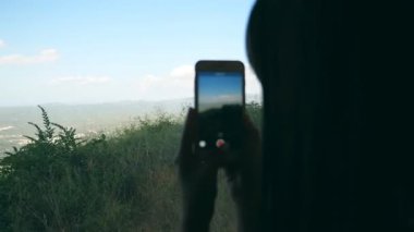 Genç bir kadın trendeyken akıllı telefondan video çekiyor. Güzel kız, yolcu treniyle seyahat eden güzel doğayı cep telefonuyla kaydediyor. Geçmişe odaklan. Yavaş çekim