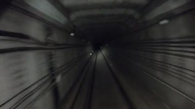 Yeraltı treni karanlık tünelde ilerliyor. Metro treni karanlık tünelden hareket ediyor. Ulaşım için tren istasyonlarına gelen şehir metrosu. Demiryolu kulübesinden bakış açısı. Zaman aşımı.