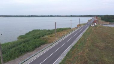 Göl kenarındaki yolda motosikletle gezen motorcuya. Motosikletli, yaz günü baraj yolunda motosikletiyle yarışıyor. Yolculuk sırasında bisiklet süren bir adam. Özgürlük ve macera kavramı.