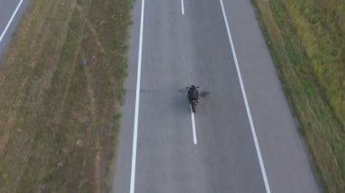 Yolculuk sırasında motosiklet kullanan motorcuya en iyi manzara. Adam otoyolda modern spor motosikletle hızlı gidiyor. Motosikletli, kır yolunda bisikletiyle yarışıyor. Yolculuk ve macera kavramı. Hava görüntüsü.