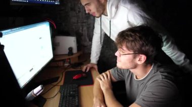 Genç finansal analistler birden fazla bilgisayar ekranındaki grafikleri analiz ediyorlar. Erkek simsarlar döviz çizelgelerini değiştirmekten endişeleniyorlar. Borsada haberler kötü. Bitcoin BTC ve kripto ticareti kavramı.