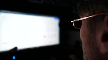 Geceleri bilgisayar üzerinde çalışan finansal analistlerin profili. Erkek tüccar gerçek zamanlı hisse senetleri ve döviz çizelgelerini inceliyor. Akşamları genç analitik ticaret çevrimiçi oluyor. Serbest meslek kavramı.
