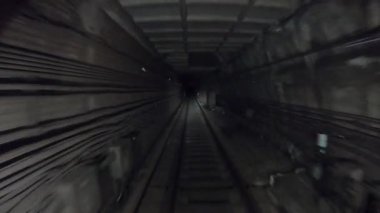 Yeraltı treni karanlık tünelde ilerliyor. Metro treni karanlık tünelden hareket ediyor. Ulaşım için tren istasyonlarına gelen şehir metrosu. Demiryolu kulübesinden bakış açısı. Zaman aşımı.
