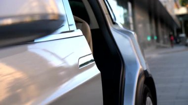 Şehir ortamında kapatılan modern elektrikli SUV 'nin arka yolcu kapısı. Çağdaş teknoloji ve ekoloji dostu ulaşım kavramı. Yavaşça kapat..