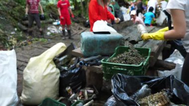 Bir sürü koruyucu eldivenli gönüllü dışarıda şişe çeşitlendiriyor. Tanımlanamayan çevreciler doğada plastik ve cam kullandılar. Çevre kirliliği koruması kavramı. Bulanık hareket.