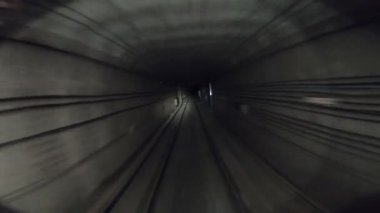 Yeraltı treni karanlık tünelde ilerliyor. Şehir metrosu yerin altında. Metro treni karanlık tünelden hareket ediyor. Demiryolu kulübesinden bakış açısı. İnsan taşımacılığı kavramı. Yavaş çekim.