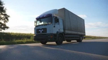 Kamera bir otoyolda sürüş kamyon aşağıda verilmiştir. Arka plan, güzel manzara ile kırsal yoluyla kamyon sürmek. Yan görünümü ağır çekim yakın çekim.