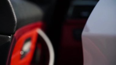 Arabanın kapı koluyla el ele tutuşuyor, giriş anını gösteriyor, araçların iç mekanlarının zarif tasarımını ve davetkar atmosferini yakalıyor.