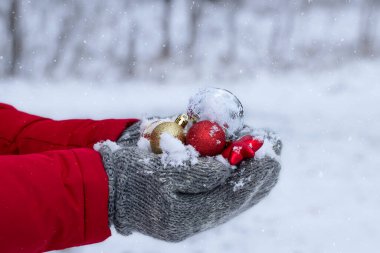 Kış aylarında Noel baloları. Yumuşak eldivenli erkekler Noel balolarını karda tutarlar..