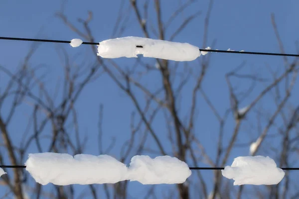 Electrical wires in the snow.High-voltage wires are covered with snow after a snowfall.