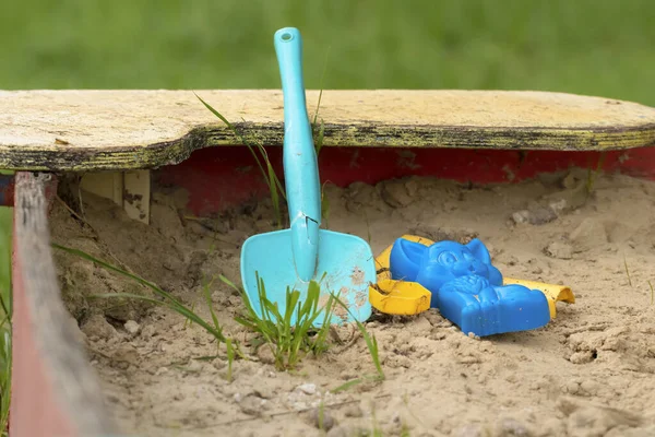 Children\'s toys in the sandbox.Broken toys in an old dirty sandbox.The concept of destruction and decay.