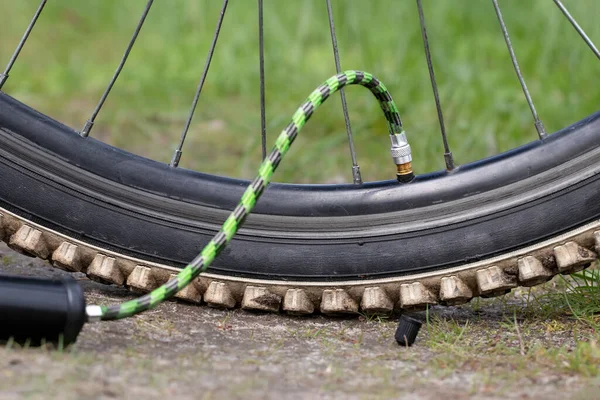 Close-up of bicycle tire inflating valve.Pump valve connected to the wheel.