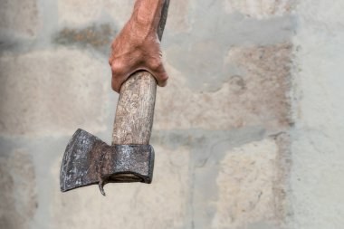 Yaşlı balta. Elinde yakacak odun kesmek için paslı bir balta tutuyor..