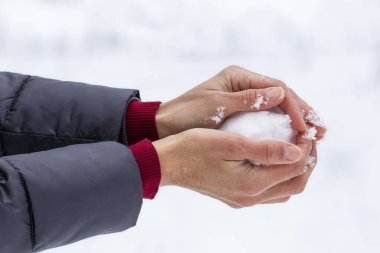 Eldivensiz kız kartopu yapıyor. Kış etkinlikleri. Kış oyunları..