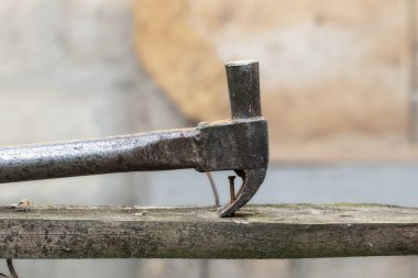 Çivi sökücü tahtadaki çiviyi söküyor. Atölyede küçük marangozluk işi. Ev yenilenmesi.