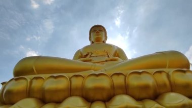 Wat Pak Nam Phasi Charoen tapınağındaki Altın Buda heykeli (Phra Buddha Dhammakaya Thep Mongkol). Güneş ışığı gökyüzü ve bulut arkaplanı