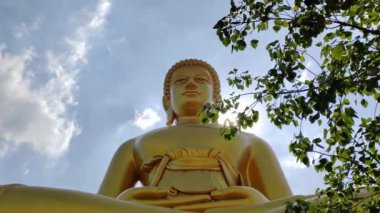 Wat Pak Nam Phasi Charoen tapınağındaki Altın Buda heykeli (Phra Buddha Dhammakaya Thep Mongkol). Güneş ışığı gökyüzü ve bulut arkaplanı