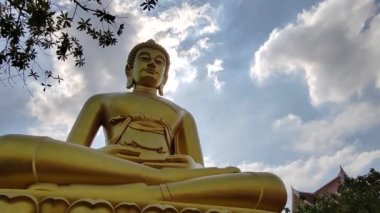 Wat Pak Nam Phasi Charoen tapınağındaki Altın Buda heykeli (Phra Buddha Dhammakaya Thep Mongkol). Güneş ışığı gökyüzü ve bulut arkaplanı