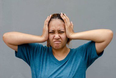 Asyalı kadınlar şakaklarına dokunur, baş ağrısı ya da baş dönmesi hissederler, yorgun hissederler. Ağrı kesicilerin gri arka planda durması gerek.