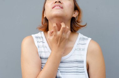 Genç Asyalı kadın elini boğazına sürterek kaşınıyor, sağlık konsepti.