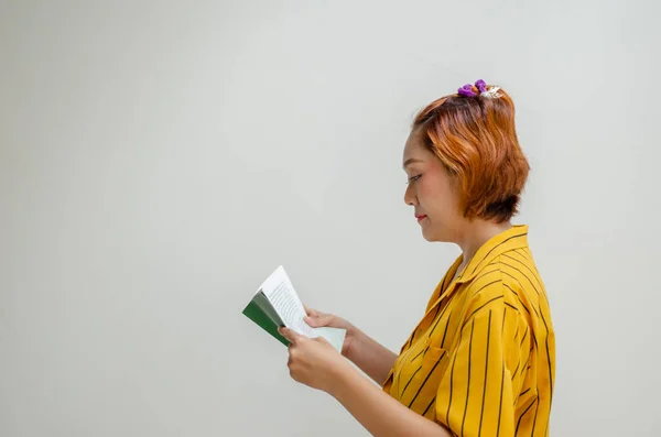 stock image young woman posing standing and reading a book isolate on white background