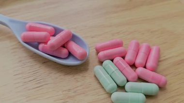 Kaşık üzerindeki vitaminler ve tahta tahtadaki vitaminler bir sağlık hizmeti konseptini ve gıda takviyesini temsil eder..