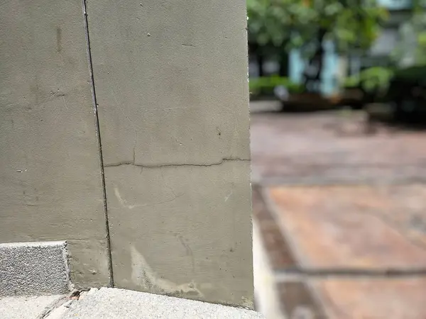 Çatlak beton ve duvarları olan bir bina, özellikle de dış çimento sütunlarının köşelerinde..