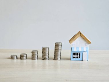 Ev modeli ve yığınla para sikkeleri konsepti kredi, tasarruf ve kopyalama alanı ile yatırım