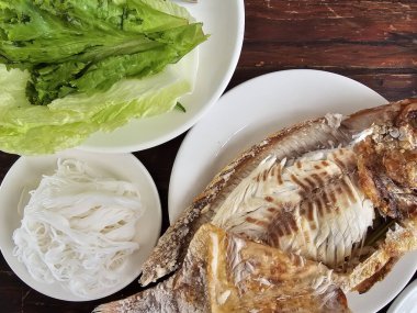 Tuz kabuklu ızgara Red Tilapia balığı ve sebze tabağı ve beyaz tabakta Tayland pilavı. Masa yemeğinin üzerinde. yüksek açı görünümü