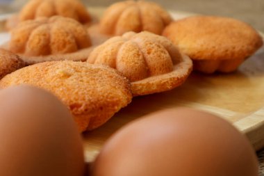 Side view Thai egg cake with or as it is known in Thai, Khanom Khai, on wooden board Made by baking, it is crispy on the outside and soft on the inside. clipart