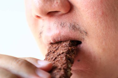 Genç Asyalı adam sağlıklı granola çikolatası ya da kakao aromalı yiyor. Refah kavramı