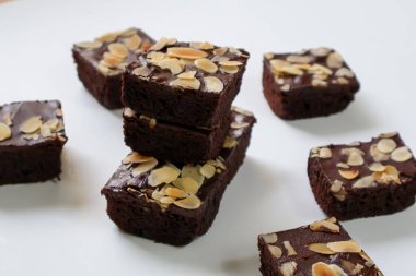 Beyaz arka planda badem dilimli çikolatalı kek. yan görünüm