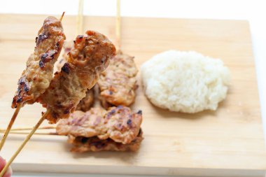 Elinizde iki ızgara domuz şişi, Tayland sokak yemekleri kahvaltıda çok sevilirdi. kopyalama alanı ile