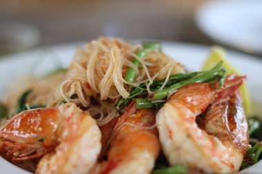 Karıştırılmış Vermicelli 'nin yan görüntüsü ve ahşap zemin üzerinde karidesler olan Water Mimosa. Kapat.