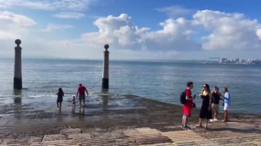 Lizbon 'da bir tekne rampasında duran insanlar.