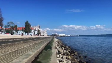 Lizbon 'daki Tagus nehrinin kıyısında yürüyen insanlar.