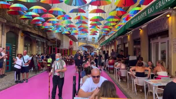 Turis Nongkrong Jalan Merah Muda Dengan Payung Pelangi Berwarna Warni — Stok Video