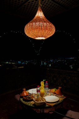Gece yarısı hasır lambalı bir yemek masasında.
