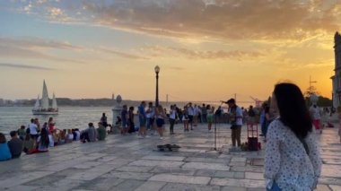 Erkek müzisyen Lizbon 'da Praca do Comercio' nun yanında gitar çalıp şarkı söylüyor.