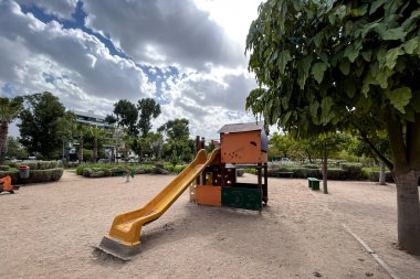 Çocuk parkında kumların üzerinde bir sürgücü.