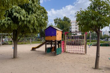 Çocuk parkında kumların üzerinde bir sürgücü.