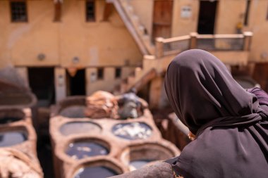 Fez 'in eski Medine' sindeki deri tabakhanesini izleyen Müslüman bir kadın.