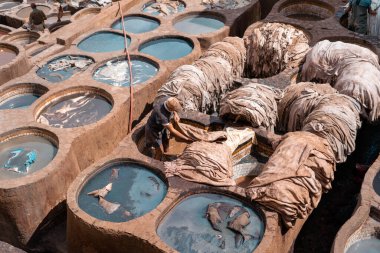 Eski Fez Medina 'daki deri tabakhanesinde bronzlaştırıcı olarak çalışan adam.