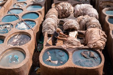 Eski Fez Medina 'daki deri tabakhanesinde bronzlaştırıcı olarak çalışan adam.