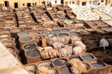 Eski Fez Medina 'daki deri tabakhanesinde bronzlaştırıcı olarak çalışan adam.