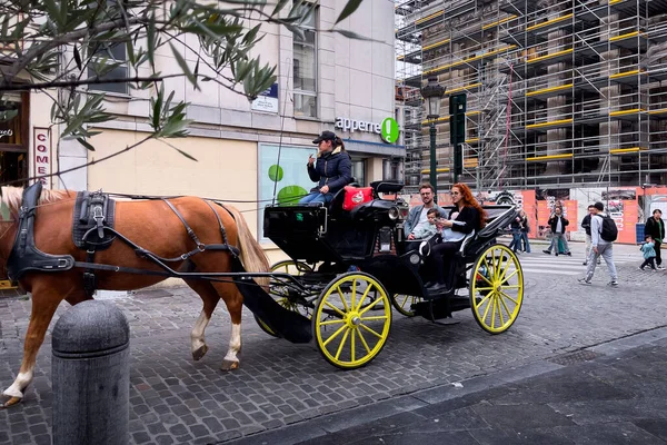 stock image Tourists taking a ride on a horse-drawn carriage in the streets of Brussels