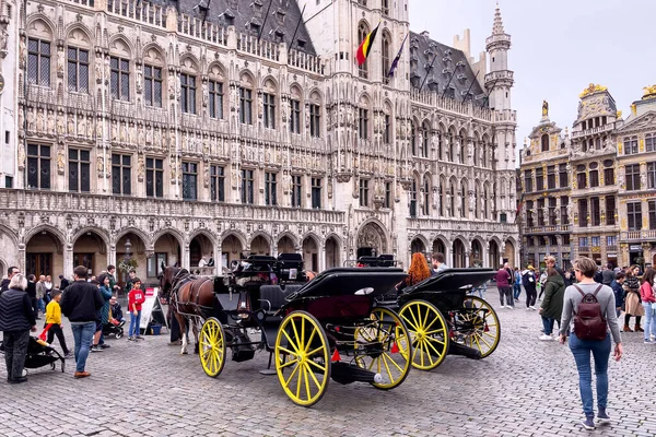 stock image Tourists walking nearby horse-drawn carriages on the Grand Place in Bruxelles 