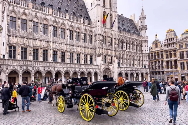 stock image Tourists walking nearby horse-drawn carriages on the Grand Place in Bruxelles 